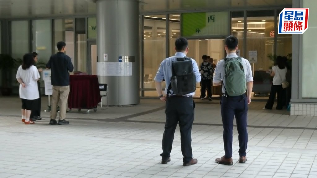 有中學派員在九龍塘學位分配組外守候，為辦理學位分配的家長即場解說，爭取收生。 　歐文瀚攝