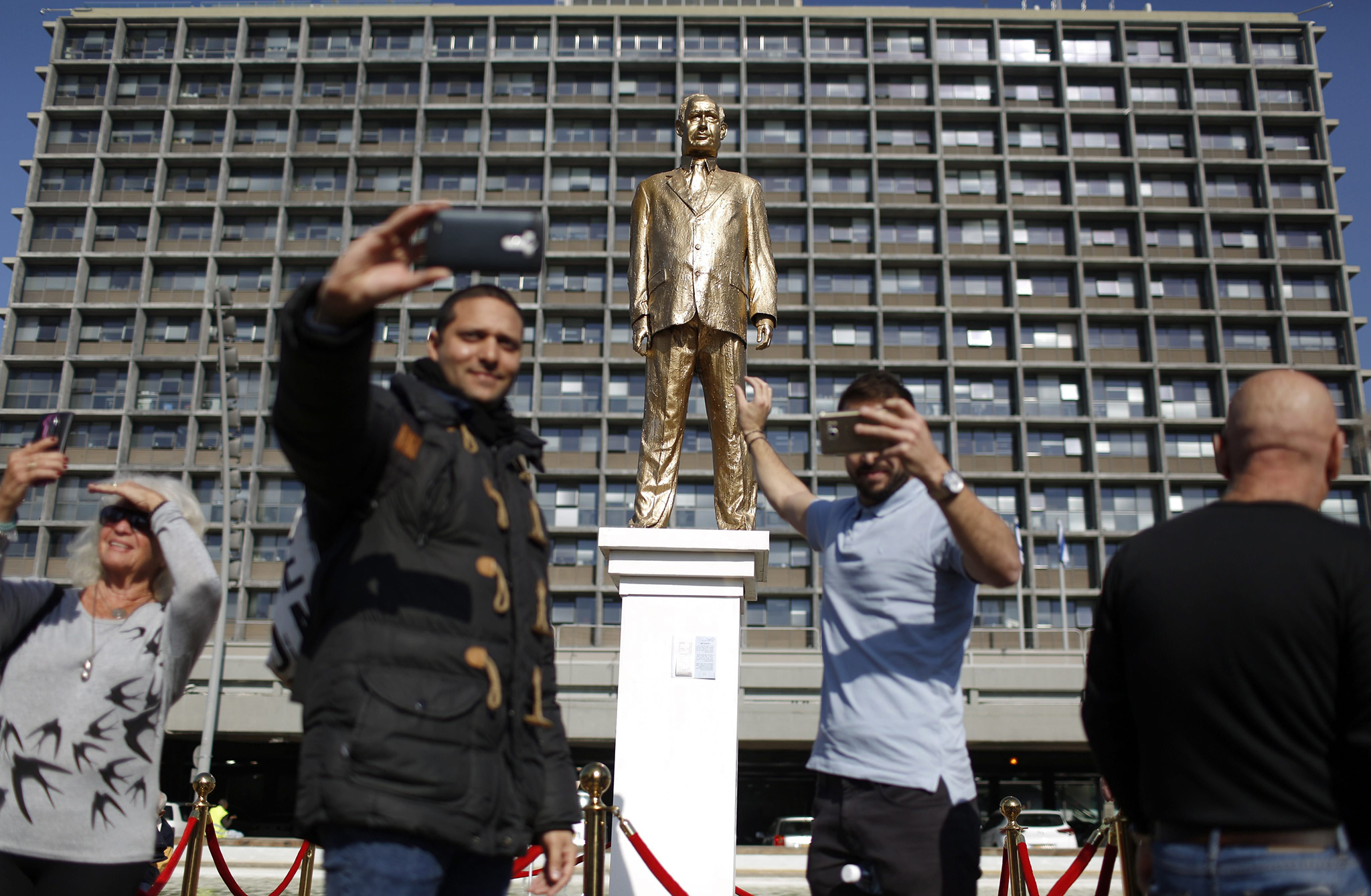 Israelis take pictures of a golden statue depicting Israeli Prime Minister Benjamin Netanyahu on Rabin Square in Tel Aviv, Israel, 06 December 2016. The statue was installed overnight by Israeli artist Itay Zalait, as a political statement against PM Netanyahu. EPA/ABIR SULTAN