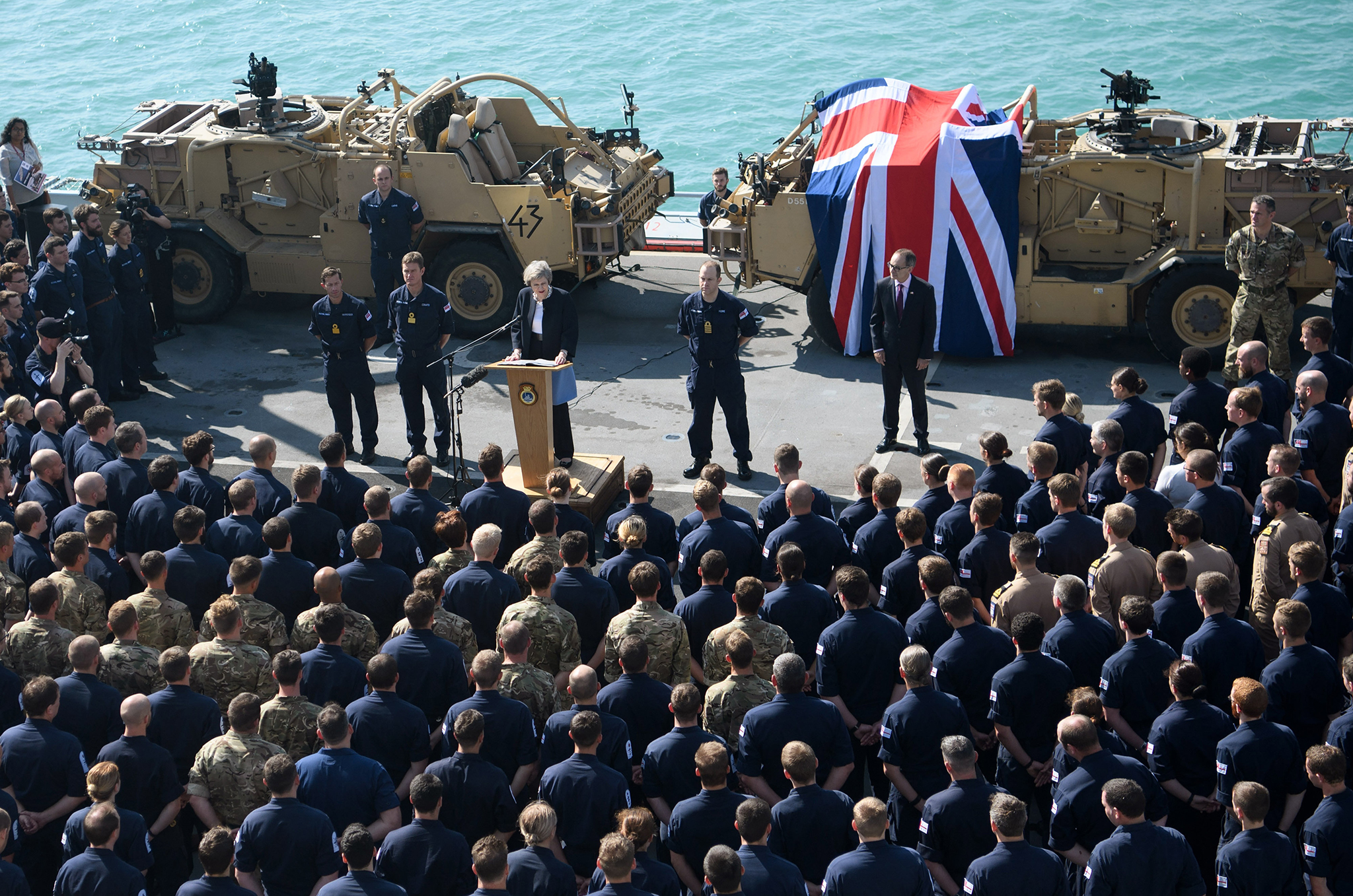 British Prime Minister Theresa May addresses sailors on board HMS Ocean during her trip to attend the Gulf Cooperation Council summit in Bahrain, on December 6, 2016 in Manama, Bahrain. Prime Minister May is the first British leader and the first woman to attend the annual two-day Gulf Cooperation Council and will attend a dinner with the leaders of Saudi Arabia, Kuwait, the United Arab Emirates, Qatar, Bahrain and Oman on Tuesday, and will also discuss the situation in Yemen and Syria. (Photo by Carl Court/Getty Images)