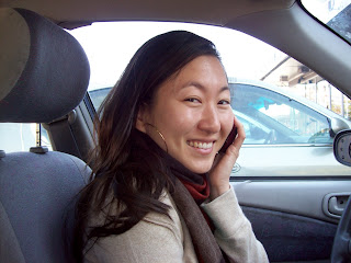 Mia sitting in her car, talking on her cell phone