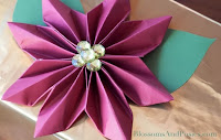 http://blossomsandposies.com/blog/origami-poinsettia-gift-topper/