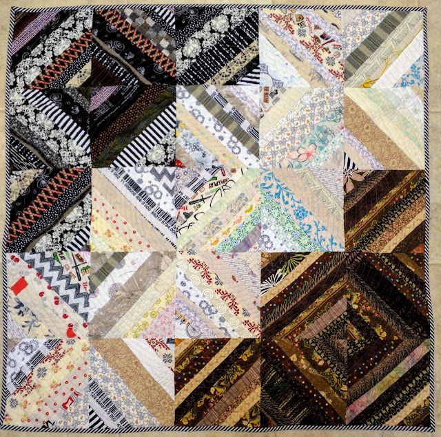 Baby quilt made of neutral strings in black, brown, and white