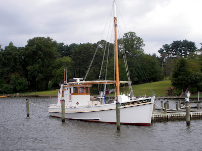 a big white wooden boat tied up to a private dock