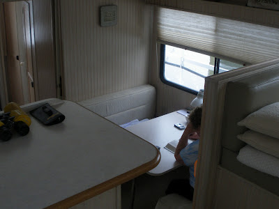 my mom reading a book on the houseboat dining table