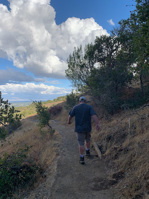 My son, hiking on a blue sky cloudy day.