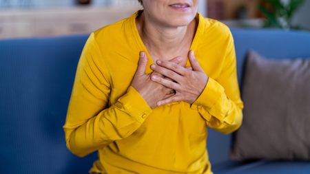 Woman with two hands on chest.
