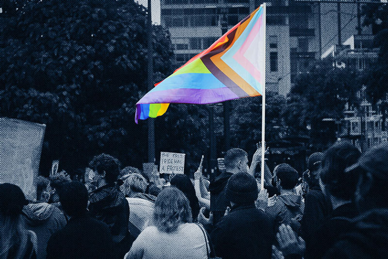 A lively group of people gathered together, holding a rainbow flag to show support for LGBTQ+ rights and equality.