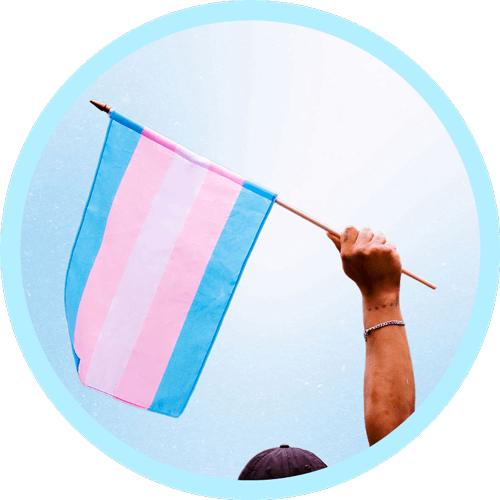 A person stands with a transgender flag, highlighting the blue, pink, and white colors, symbolizing transgender pride and identity.