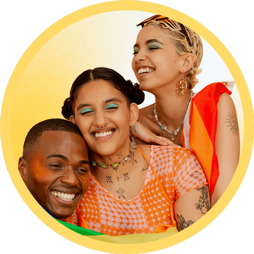 Three people are joyfully smiling while holding hands, symbolizing friendship and unity.