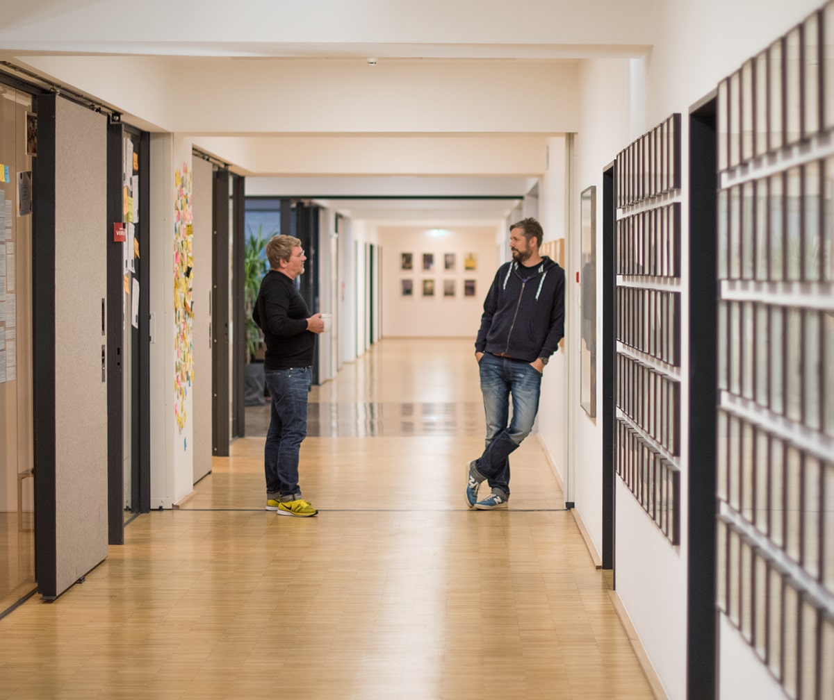 Zwei Kollegen im Gespräch im sipgate Büroflur Düsseldorf