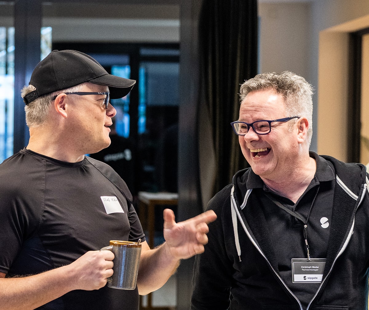 sipgate Partner lachen gemeinsam bei persönlichem Gespräch