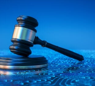 Wooden judge gavel on a blue background with glowing digital circuit patterns