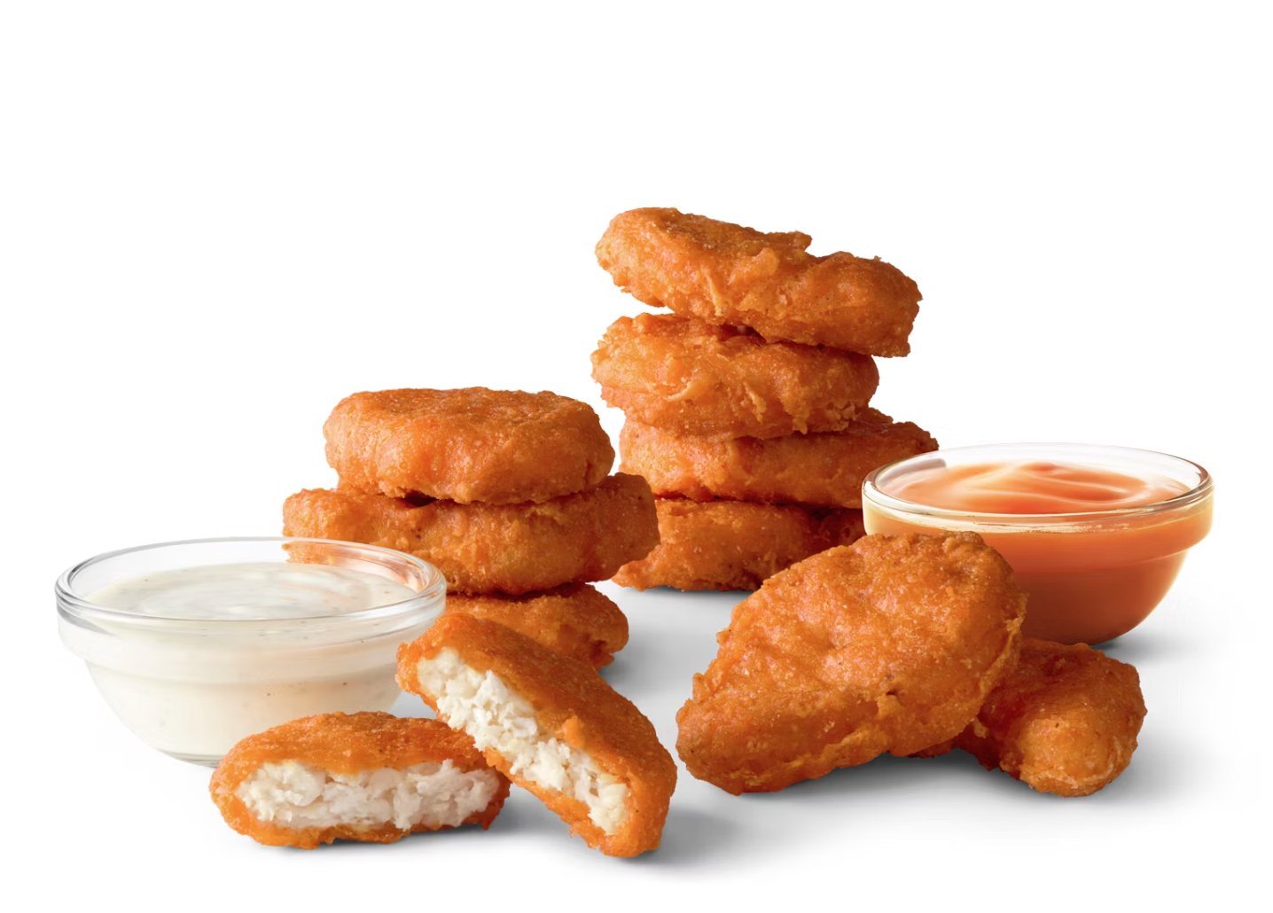 A stack of golden chicken nuggets with dipping sauces on the side.