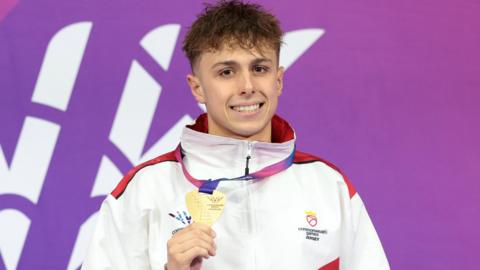 Filip Nowacki holds his Commonwealth Games gold medal around his neck