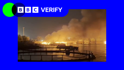 an image of a harbour on fire at night in the port city in Iran. the photo is surrounded by BBC Verify blue and green branding