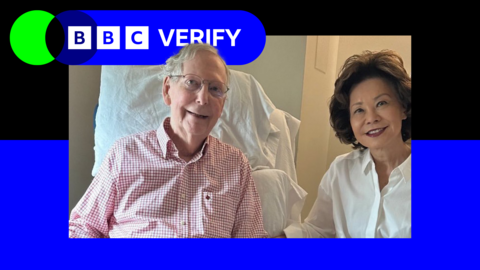 Mitch McConnell sitting in a hospital bed, wearing a pink shirt and glasses. A woman in a white shirt stands next to him and smiles. The image is surrounded by the BBC Verify branding.