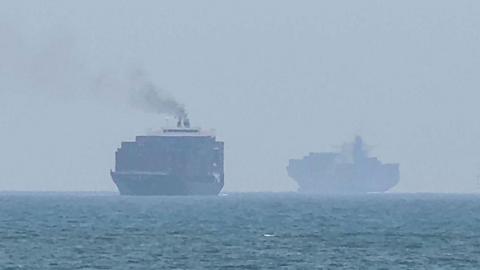 Cargo ships anchoring near the Strait of Hormuz off the eastern coast of the United Arab Emirates at Khor Fakkan on 12 July.
