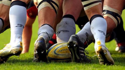 A rugby ball at the back of a scrum