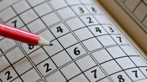 Close up of a pencil and an unsolved numeric puzzle on paper
