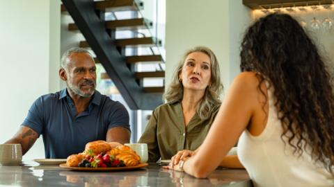 Dining Room Conversation with Mother Talking to Daughter While Father Listens - stock photo