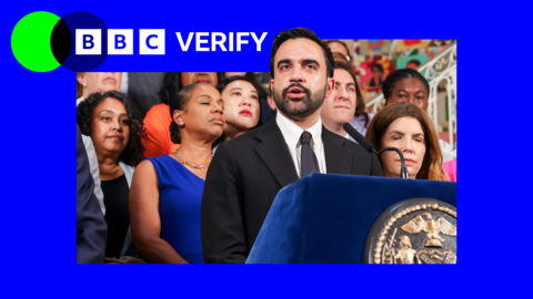 Mayor of New York City Zohran Mamdani speaks into a microphone during a press conference. In the corner there is blue and green BBC Verify branding.
