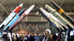 ایرانیان د ۲۰۲۵ کال د نومبر په ۱۲مه به تهران کې د توغندیو او بې پیلوټه الوتکو (ډرونونو) د لاسته راوړنو له نندارتون څخه لیدنه وکړي.