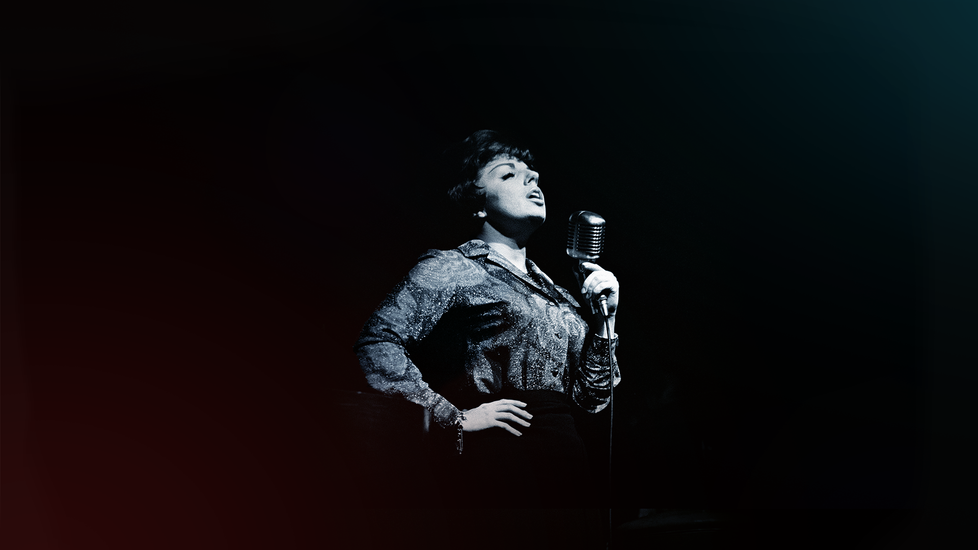 Jazz singer Carol Sloane singing into a microphone in black and white.