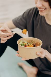 Personne tenant un bol de repas équilibré composé selon la règle de l'assiette