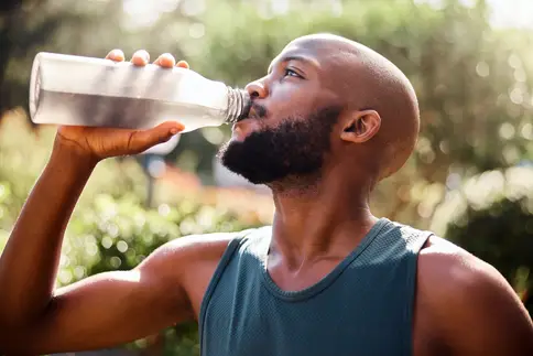 photo of man outdoors drinking bottle of water