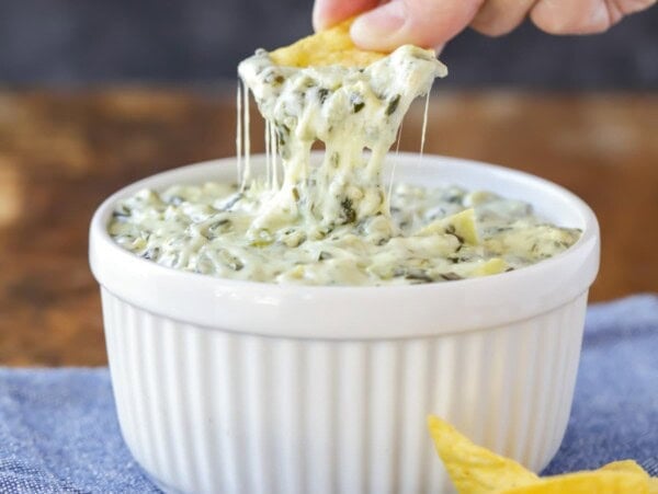 Dipping a chip into spinach artichoke dip.
