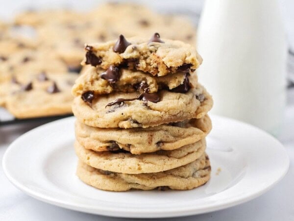 Best chocolate chip cookie recipe stacked on white plate.