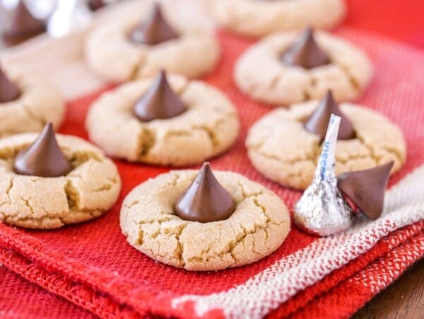 Several Hershey kiss cookies on a red tea towel.