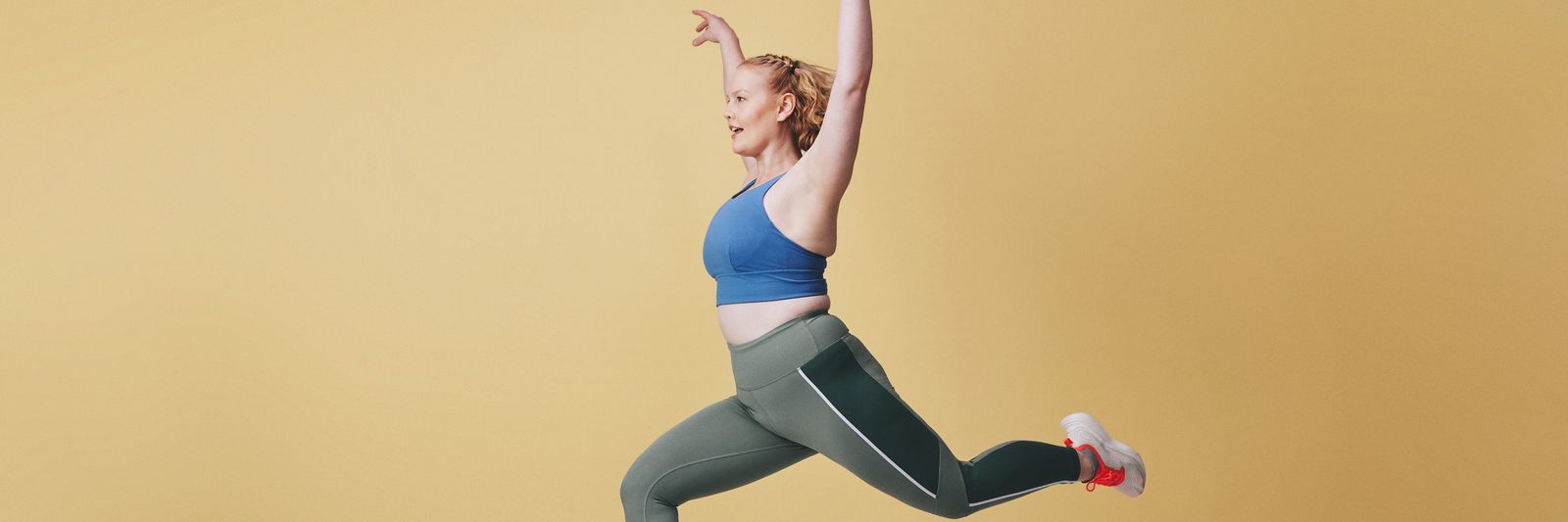 Molly leaping against a yellow backdrop