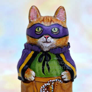 An orange cat wears a purple mask and cape with gold trim, a green shirt, and tan pants. Pearls and a pocket watch hang out of his pants pocket. Front view.