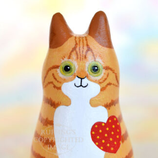 Ginger-and white-tabby cat figurine front view with a red heart with yellow polka dots