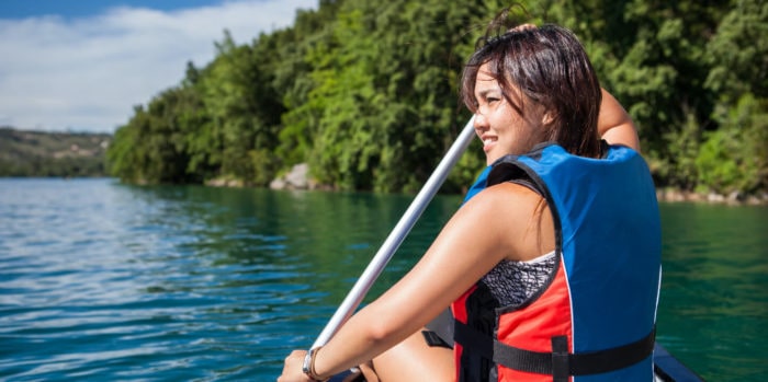 activities-paddle-image@2x | Trans Canada Trail A woman in life jacket paddling on lake