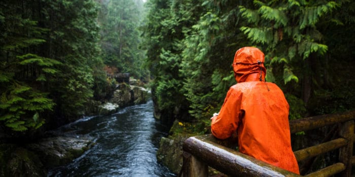 activities-relax-image@2x | Trans Canada Trail Person in orange hooded jacket overlooking river in forest