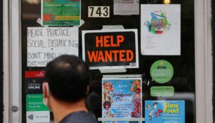 A pedestrian passes a "Help Wanted" sign in the door of a hardware store in Cambridge, Massachusetts, on July 8, 2022. (REUTERS/Brian Snyder/File Photo)