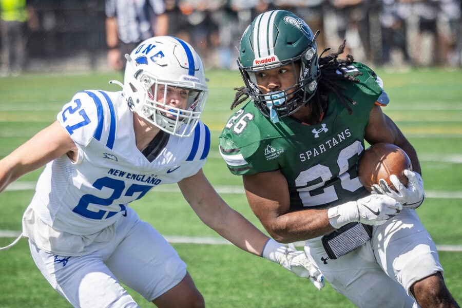 Two football players about to collide in the field