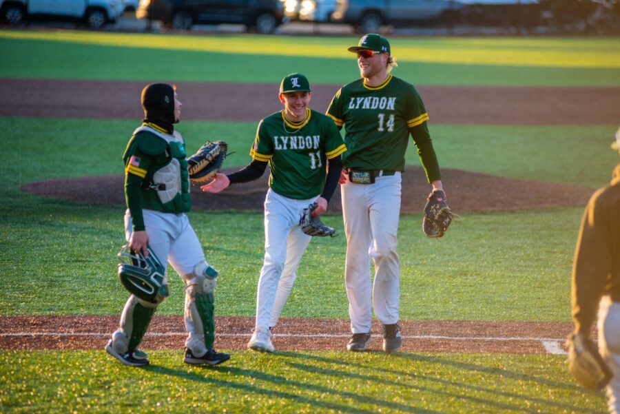 Three VTSU Lyndon baseball players high five on the field