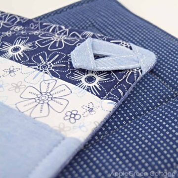 blue quilted potholder in a classic look with a hanging tab
