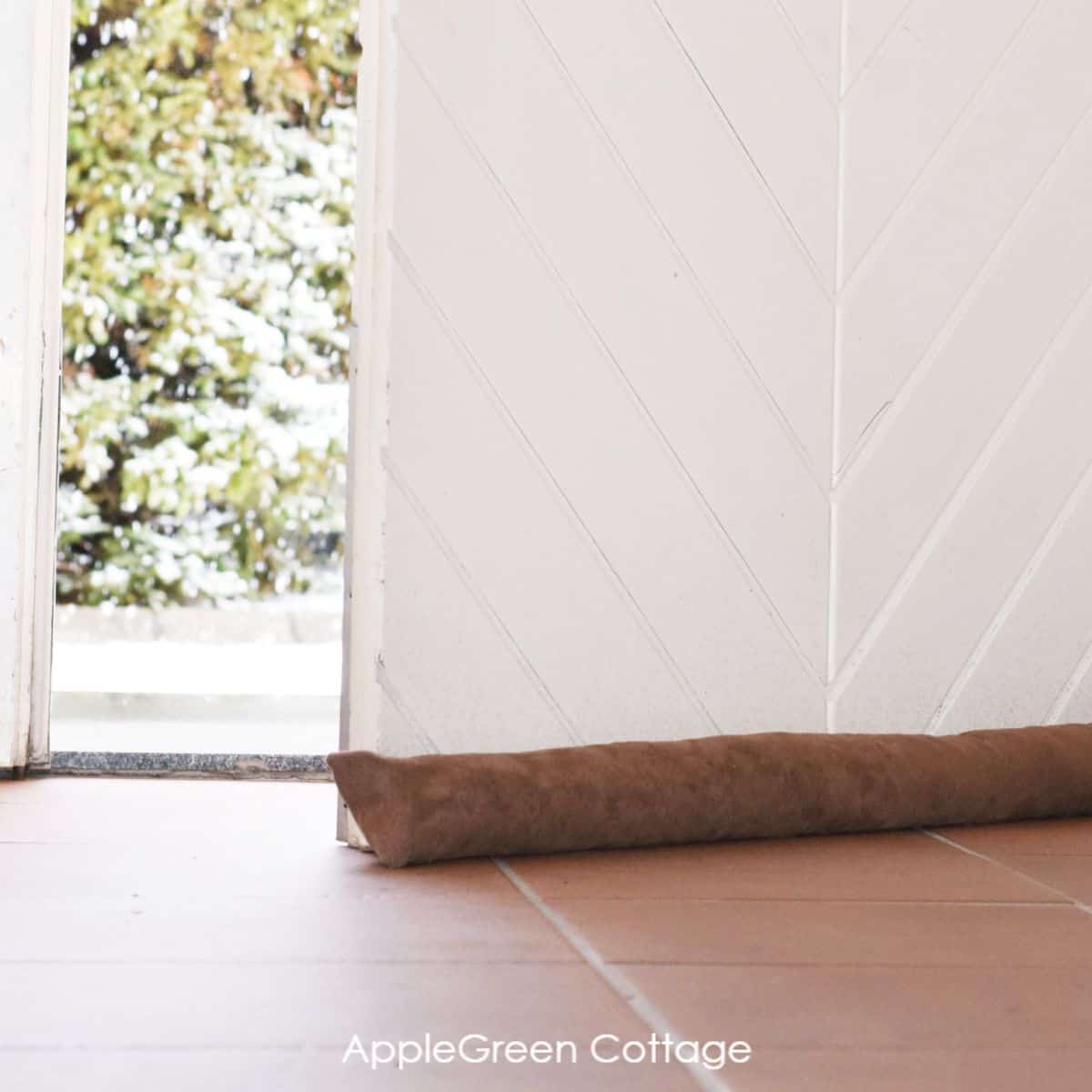 a finished brown diy door draft stopper placed under the entry door