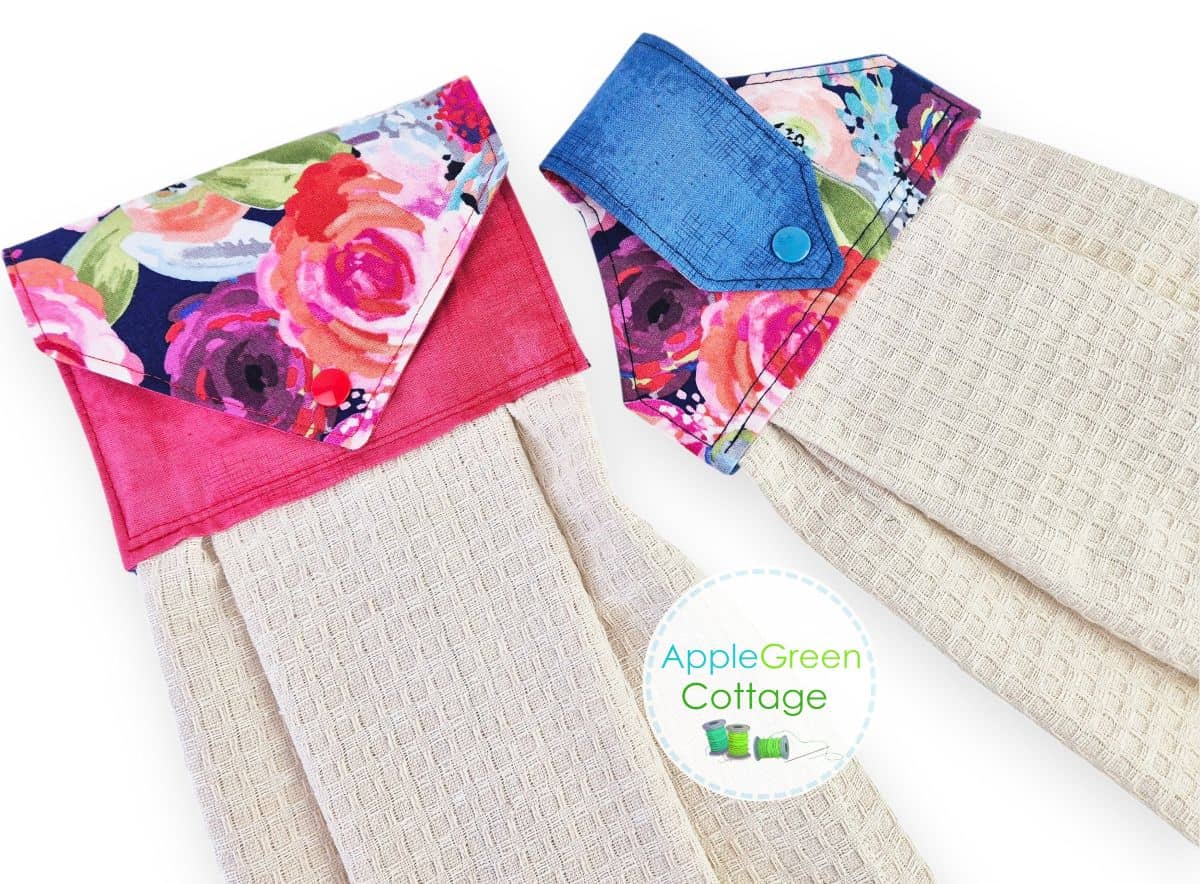 Two finished hanging kitchen towels with floral fabric toppers and kam snaps.
