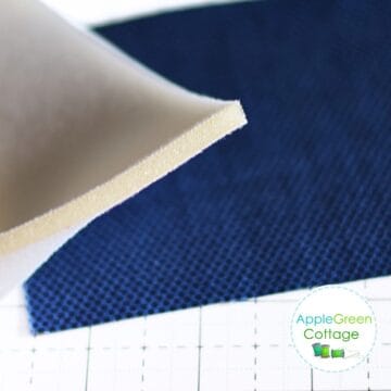 sew-in foam for bagmaking shown from a side and placed over a navy piece of fabric.