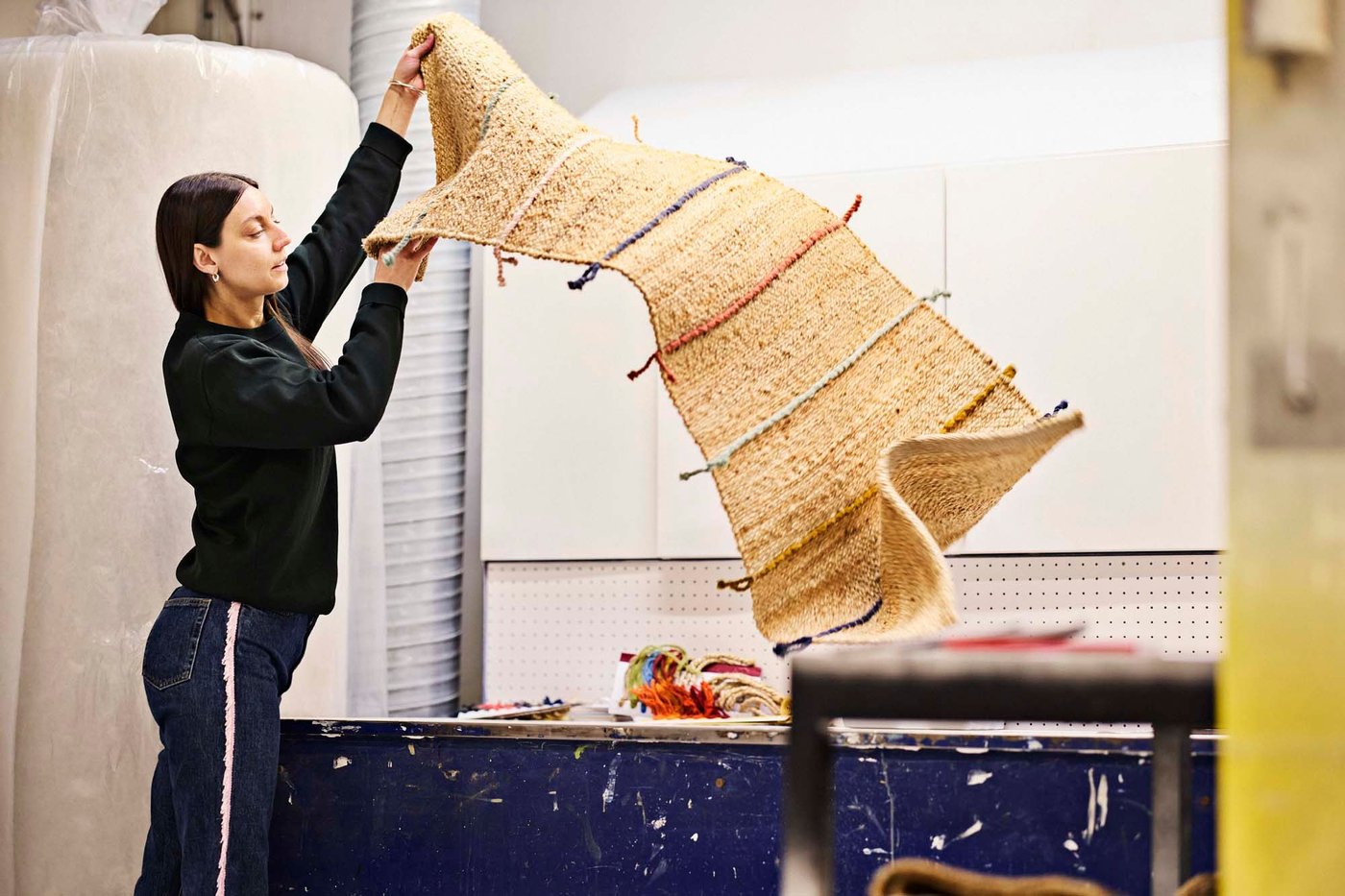 Paulin Machado shakes out a RAKLEV rug.