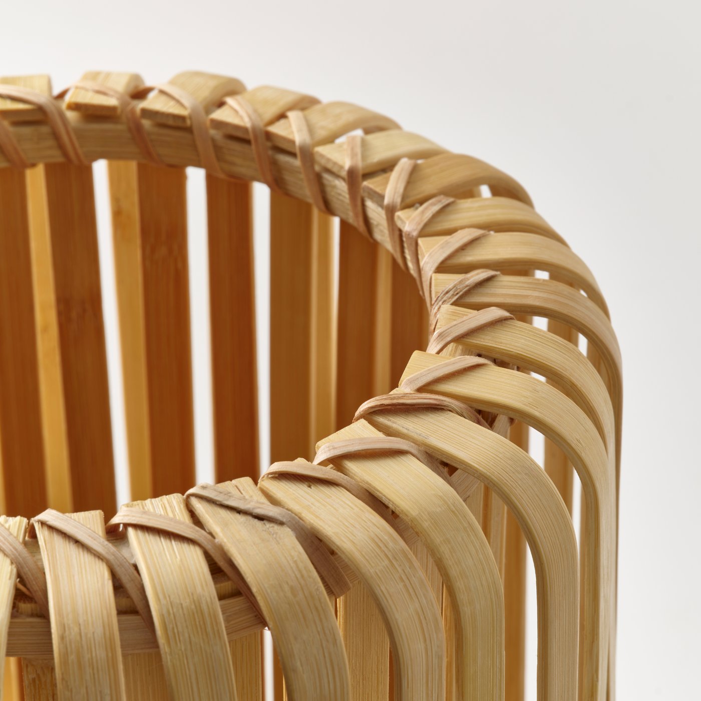 Close up of a VARPTROSS table lamp made from woven strands of bamboo.