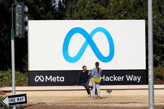 Digital_Ad_Tax_38886_61a844 FILE – People talk near a Meta sign outside of the company’s headquarters in Menlo Park, Calif., March 7, 2023. (AP Photo/Jeff Chiu, File)
