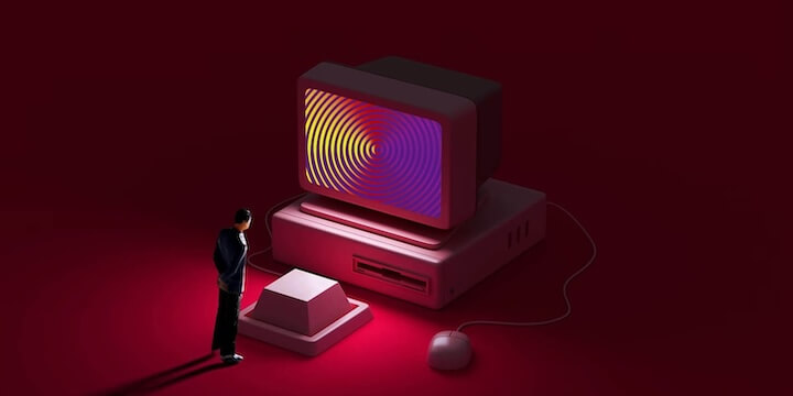 一個縮小版的人看著大按鍵和令人著迷的電腦螢幕