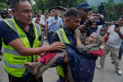 AP26238503564703 Rescuers carry a victim of flash flooding to safety along the Trishuli River.
