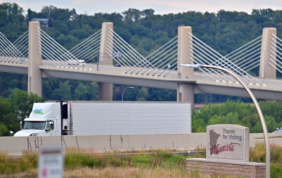 STP-L-JAKE BRAKES-0827.jpg A semi on a highway with a bridge in the background.